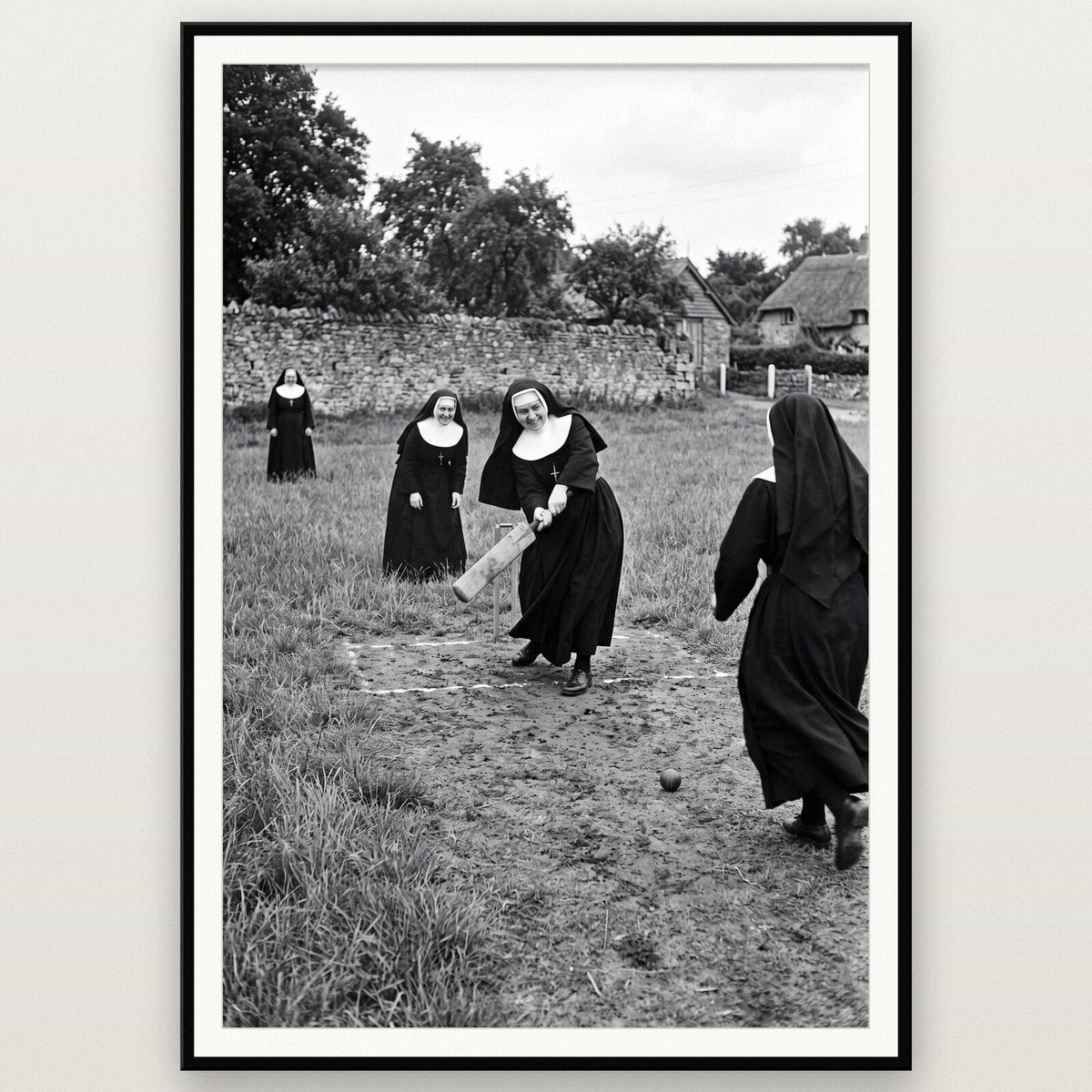 Nuns Playing Cricket shown framed on a wall