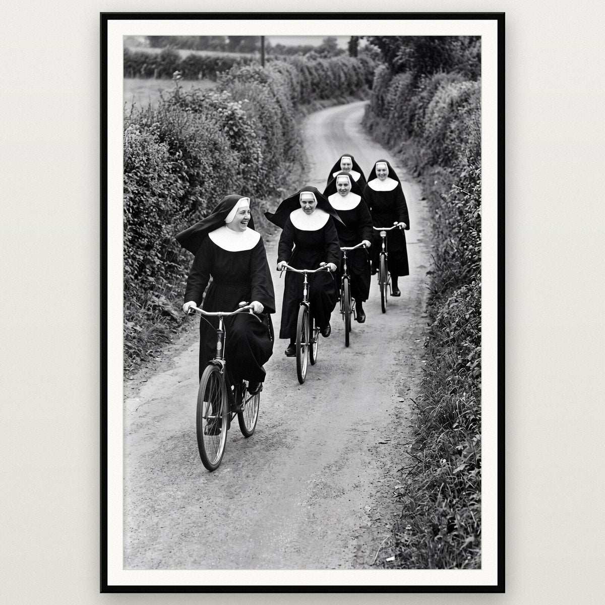Nuns On Bicycles shown framed on a wall