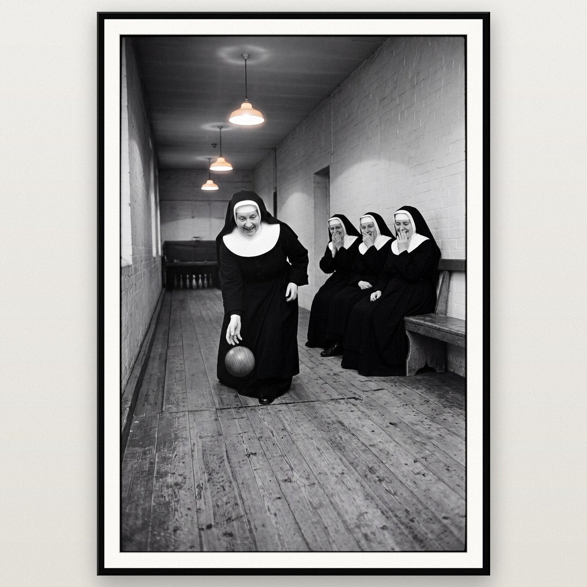 Nuns Playing Skittles shown framed on a wall