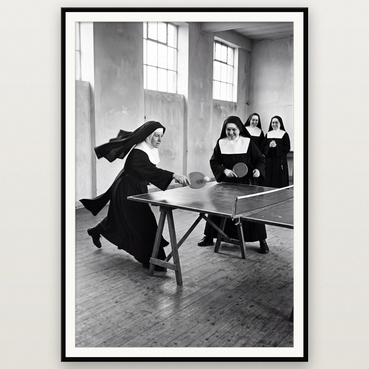Nuns Playing Table Tennis shown framed on a wall