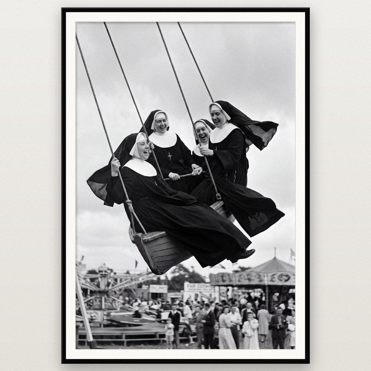 Nuns On The Swingboats shown framed on a wall