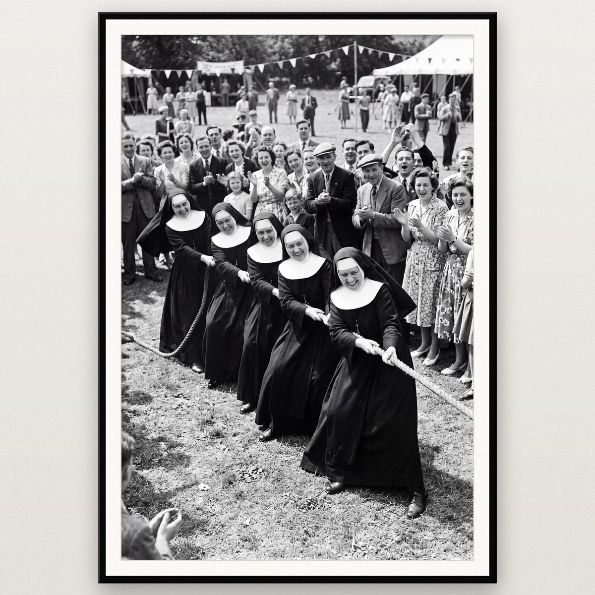 Nuns At The Tug Of War shown framed on a wall