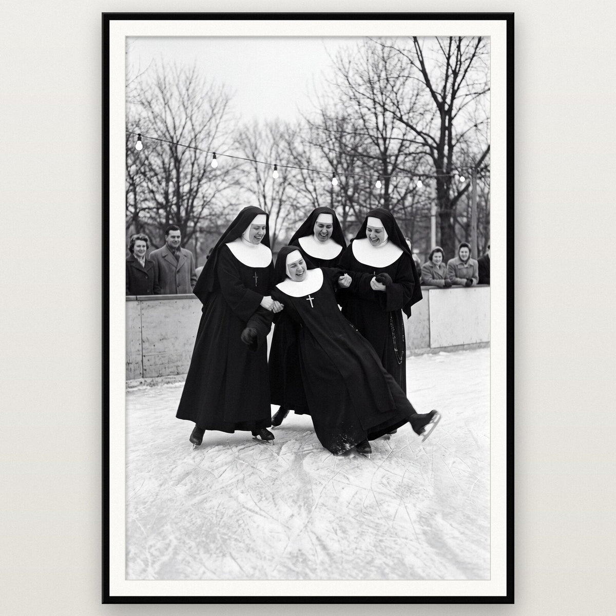 Nuns At The Ice Rink shown framed on a wall